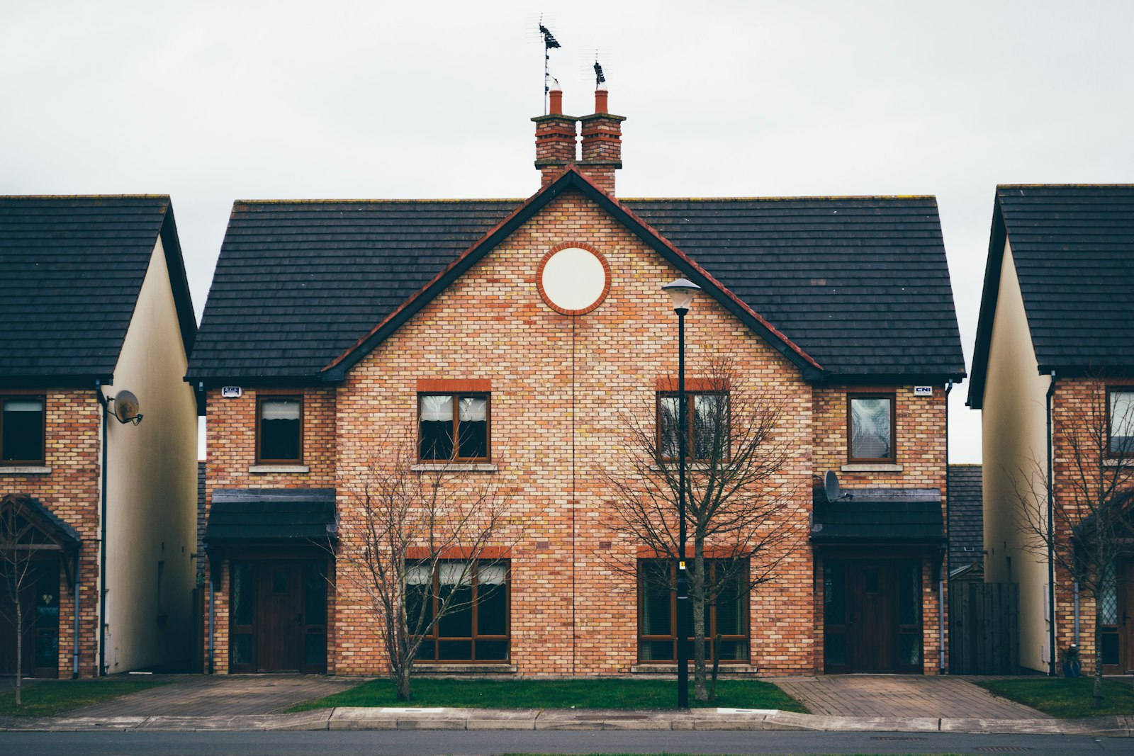 A converted stone mill building with gabled roofs and a clock
